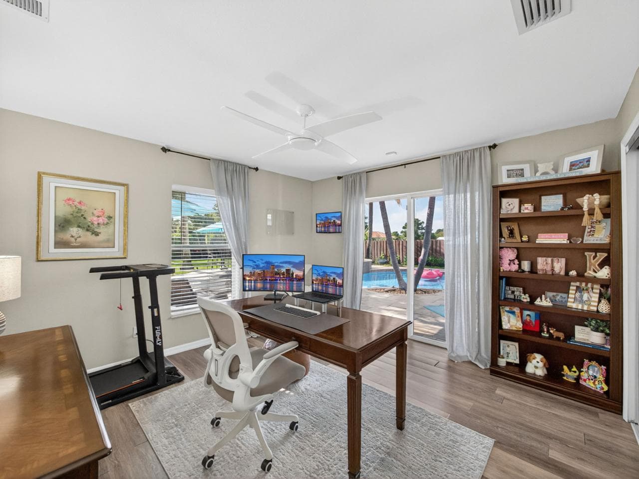 Home office with dual monitors and pool view
