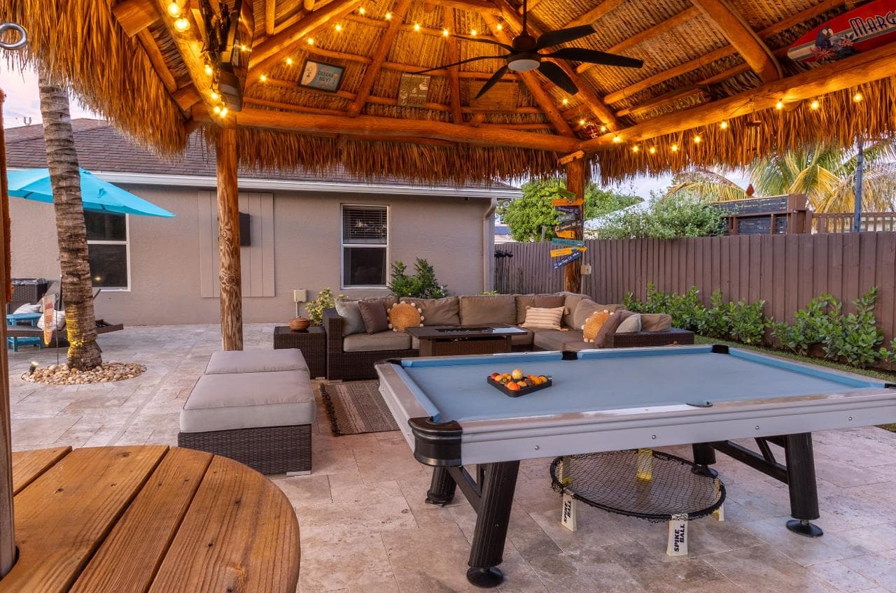 Tiki hut with fire table and string lights at night